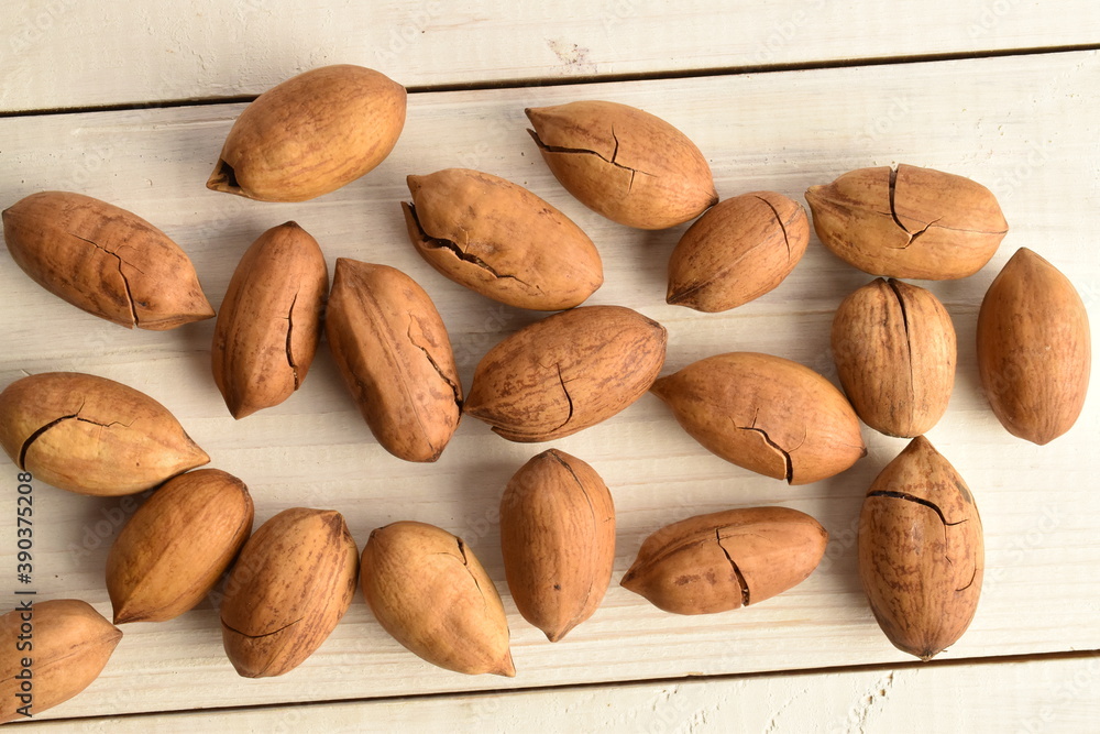 Obraz premium Not peeled pecans, close-up, on a wooden table.