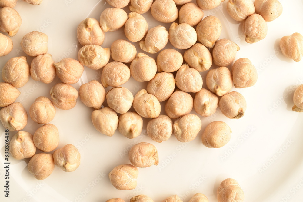 Uncooked hummus grains, close-up, on a white wooden table. Uncooked hummus grains, close-up, on a white wooden table.