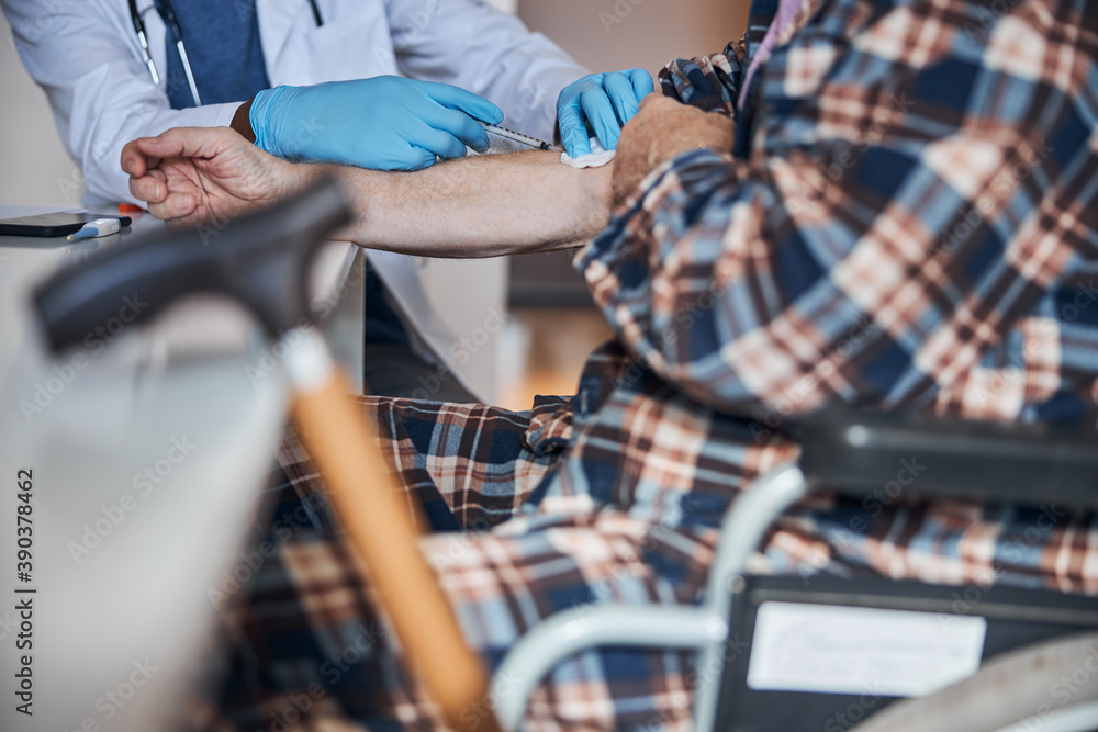Aged man getting an insulin shot into the arm Aged man getting an insulin shot into the arm