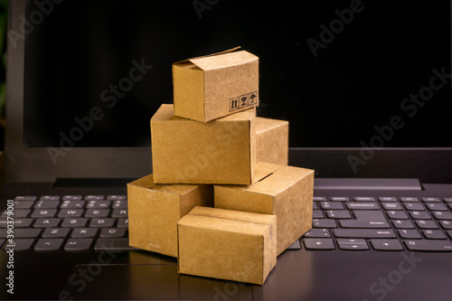online shopping concept. little deliver boxes, smartphone, shopping bags, shopping bascket stand on laptop. copy space