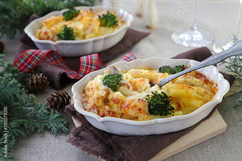 Homemade gratin with shrimp and cheese in baking dishes on Christmas decoration table. マカロニグラタン　クリスマス