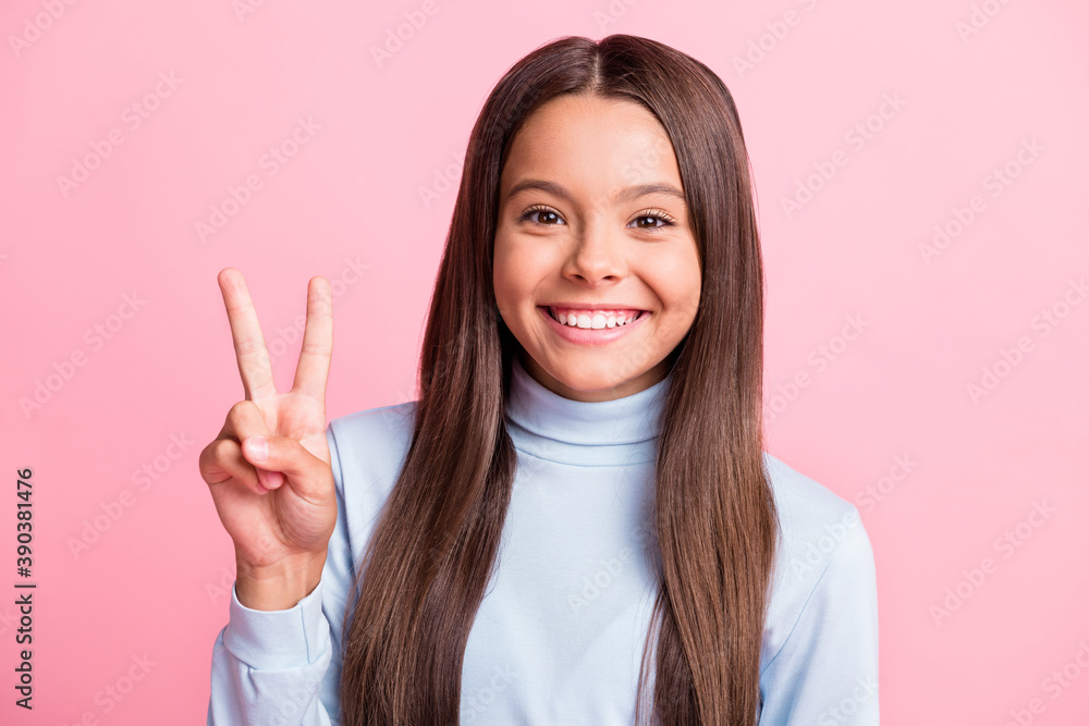 Close-up portrait of attractive pretty cheerful girl showing v-sign good mood isolated over pink pastel color background Close-up portrait of attractive pretty cheerful girl showing v-sign good mood isolated over pink pastel color background