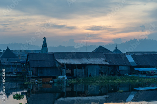 Waduk Jombor lake in the sunset with houses in the foreground, Indonesia