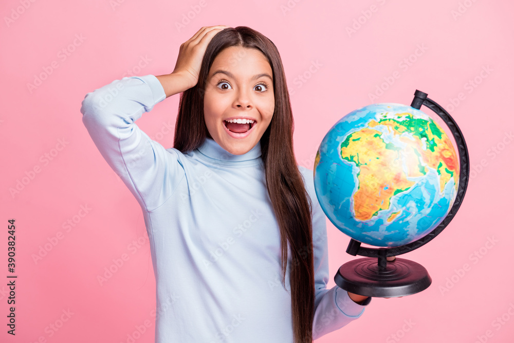 Close-up portrait of pretty cheerful amazed smart girl holding in hands globe wow isolated over pink pastel color background Close-up portrait of pretty cheerful amazed smart girl holding in hands globe wow isolated over pink pastel color background