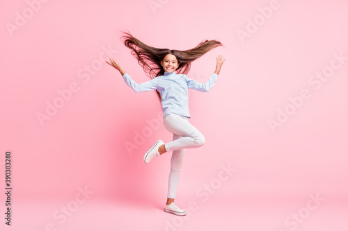 Full length body size view of charming cheerful girl throwing hair having fun isolated over pink pastel color background
