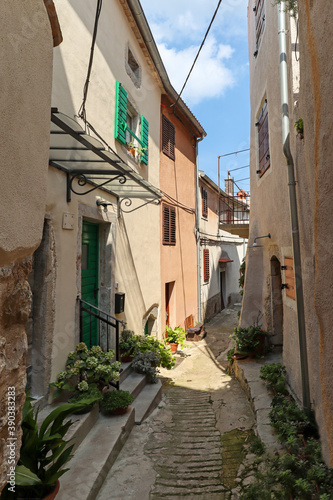 Apartment houses and footpath in the town of Vrbnik on the island of Krk  old historical buildings in summer  Croatia Europe