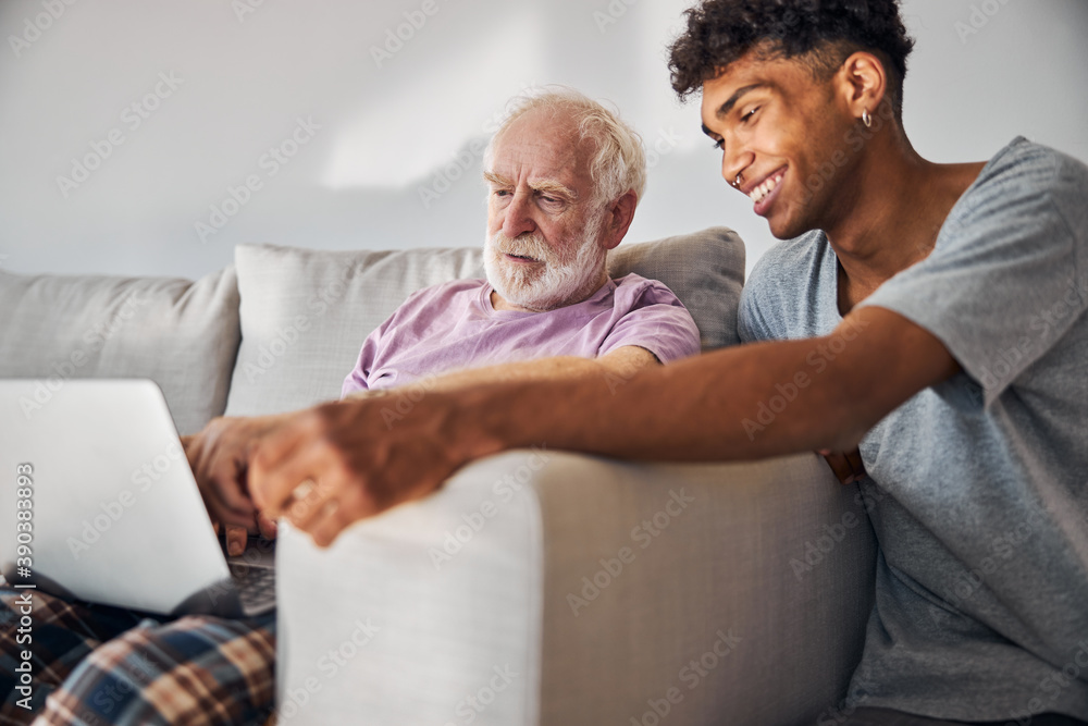 Obraz premium Aged man and his caregiver surfing the Internet
