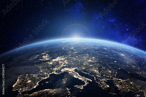 Planet Earth viewed from space with city lights in Europe. World with sunrise. Conceptual image for global business or European communication technology, elements from NASA