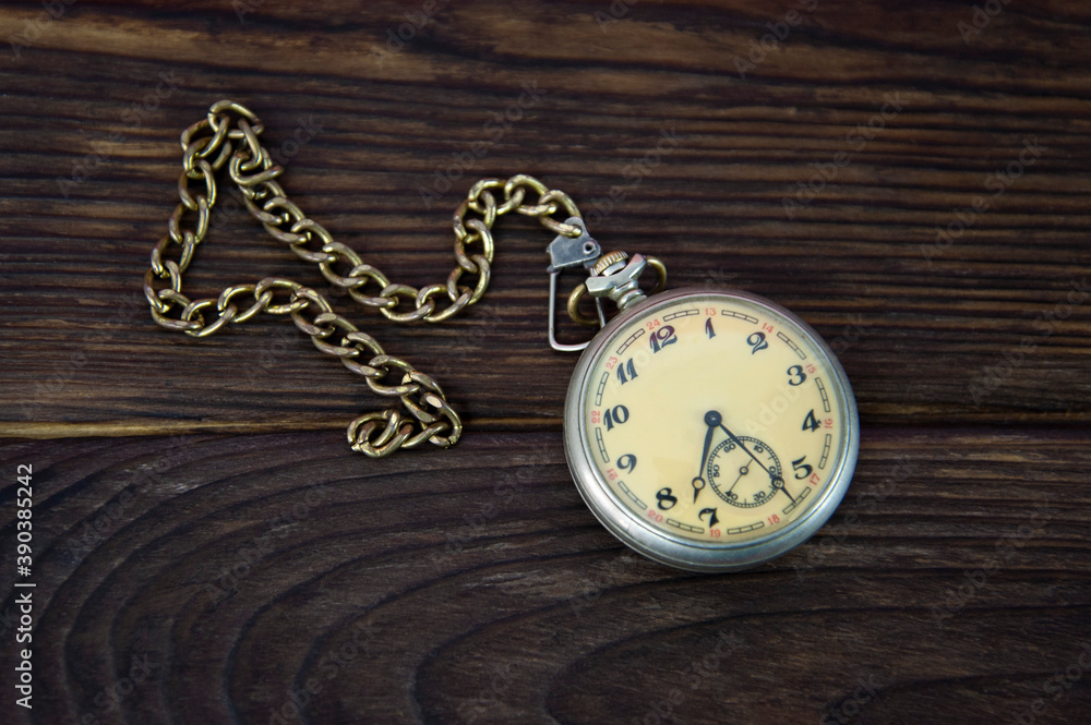 pocket watch with a cap on a wooden surface