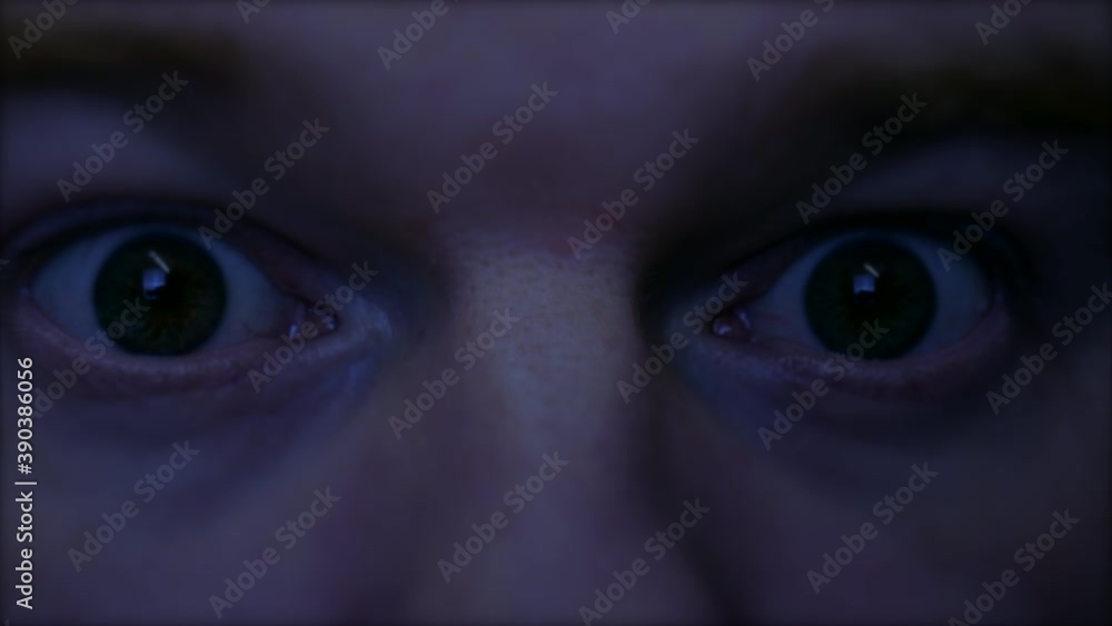 A man wakes from a nightmare. The spooky eyes are closed and in the shadows when something causes the man to awake suddenly shocked with creepy eyes wide open. A man wakes from a nightmare. The spooky eyes are closed and in the shadows when something causes the man to awake suddenly shocked with creepy eyes wide open.