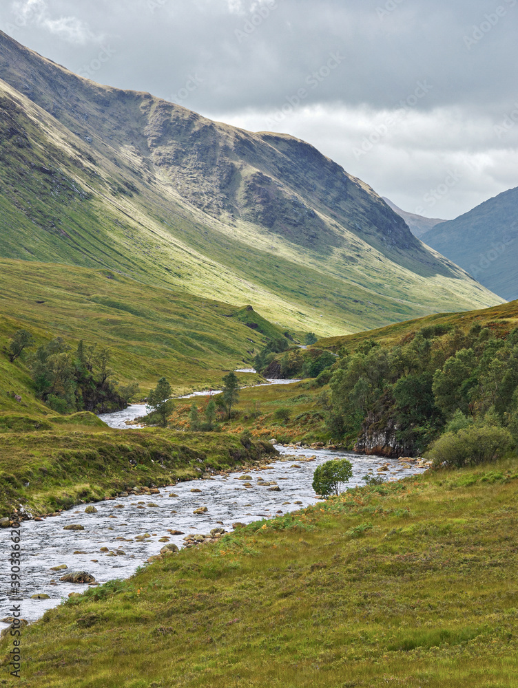 Glen Etive, a remote valley near Glencoe in the mountains of the Scottish Highlands, where the River Etive flows between banks lined with heather and bracken.