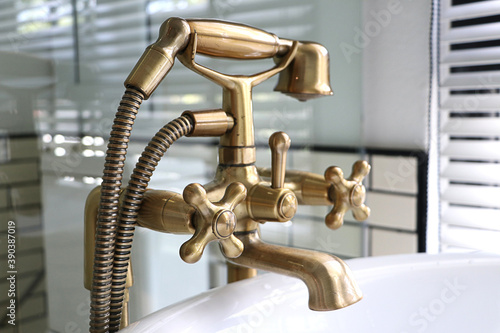 Closeup Bathtub faucet in white bathroom, Gold sanitary ware