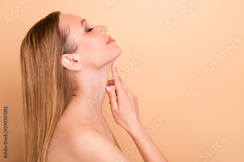 Close-up profile side view portrait of her she nice attractive lovely peaceful calm confident girl touching soft silky skin smoothing refreshment hygiene isolated over beige pastel background