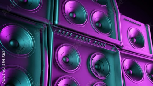 Speakers tower playing in closeup, membranes vibrating lit by colorful retro neon club lights. subwoofer and speakers stacked playing music.