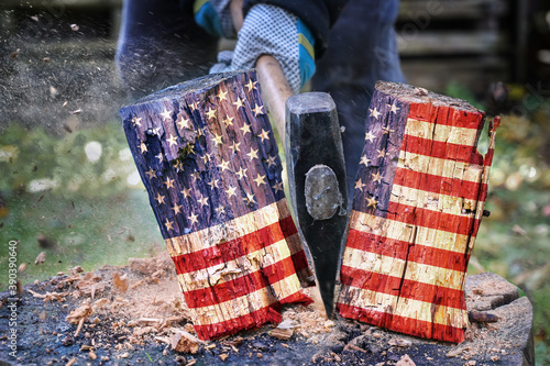 Wooden block with American flag is split in two halves with an axe, metaphor for the divided country after the election