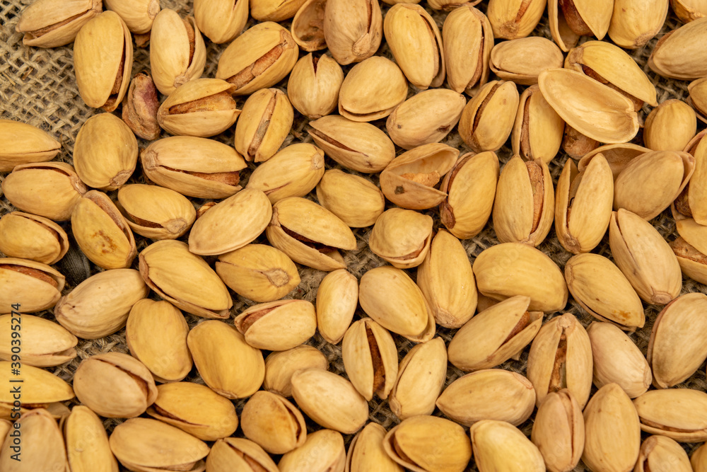 Salted pistachios lie on the burlap. Close up. Salted pistachios lie on the burlap. Close up.