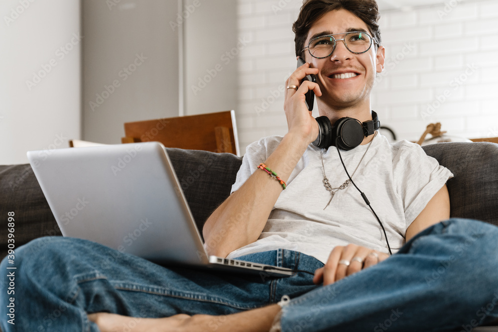 Man sitting on sofa and using laptop computer Man sitting on sofa and using laptop computer