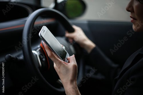 運転しながらスマートフォンの操作をする女性 © yamasan