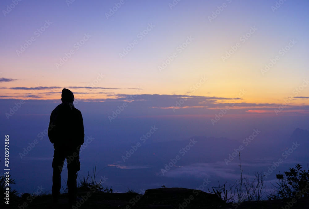 Selective focus of men's silhouette alone looking at the sunrise nature view with beautiful color background