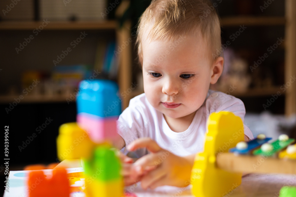 Cute little girl playing alone with many colorful toys Cute little girl playing alone with many colorful toys