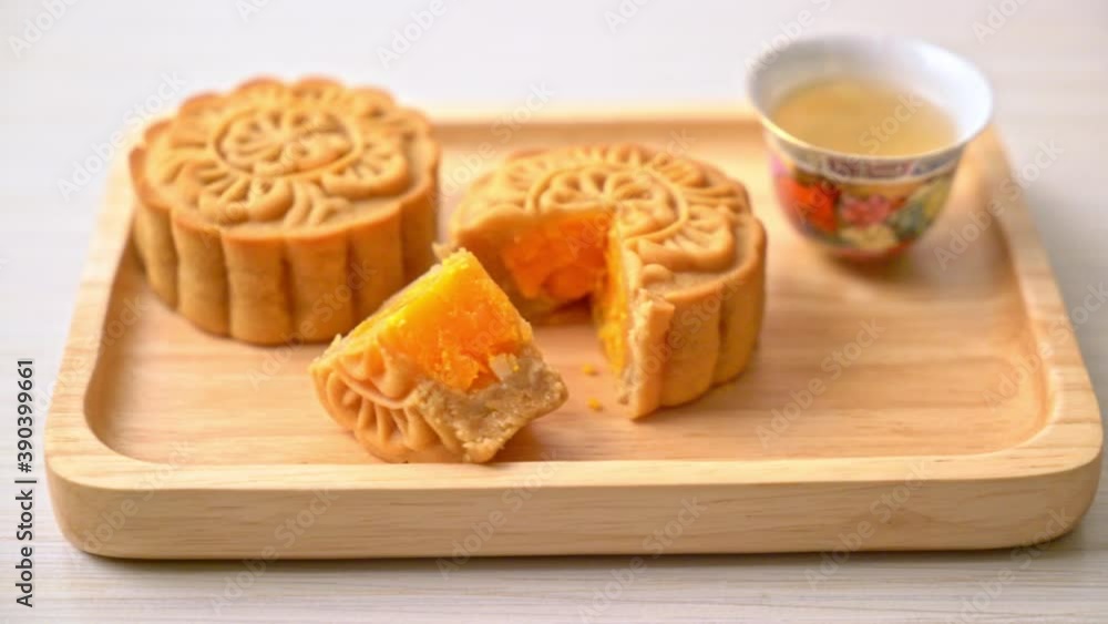 Chinese moon cake durian and egg yolk flavour with tea on wood plate Chinese moon cake durian and egg yolk flavour with tea on wood plate