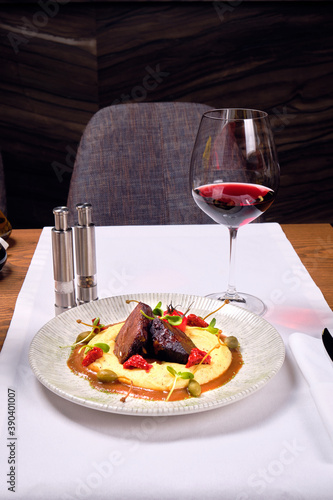 Meat dish with mashed potatoes and a glass of red wine