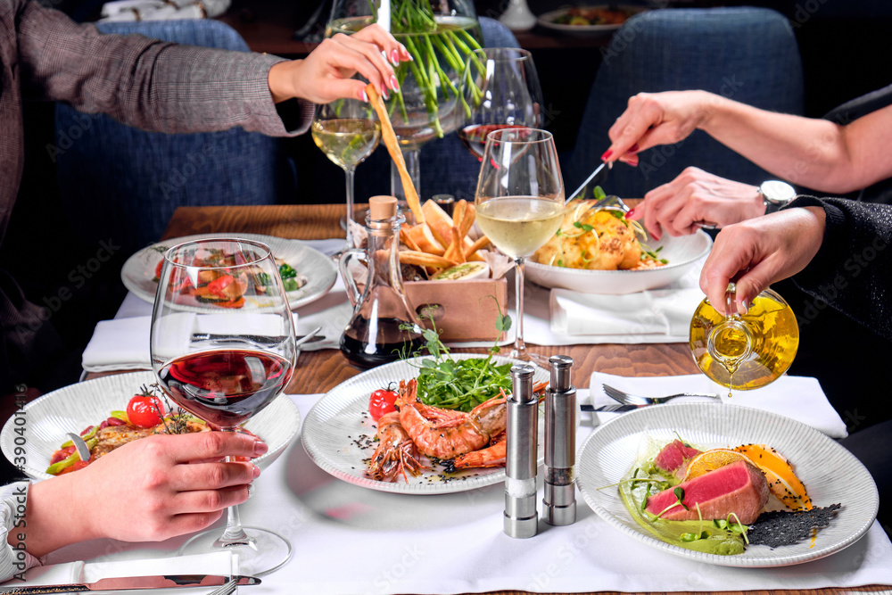 Hands of four people at a table with food. Hands of four people at a table with food.
