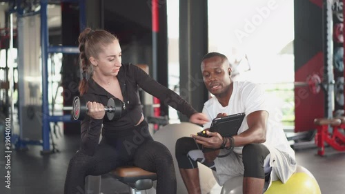 Sport woman in sportwear workouts with personal trainer at gym