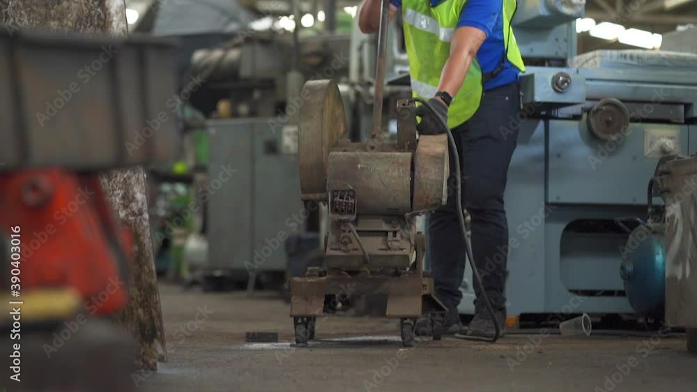 Man at work. Mechanical Engineer man in Hard Hat. Shot of sparks while cutting steel bar or steel rod in Heavy Industry Manufacturing Facility. Man at work. Mechanical Engineer man in Hard Hat. Shot of sparks while cutting steel bar or steel rod in Heavy Industry Manufacturing Facility.