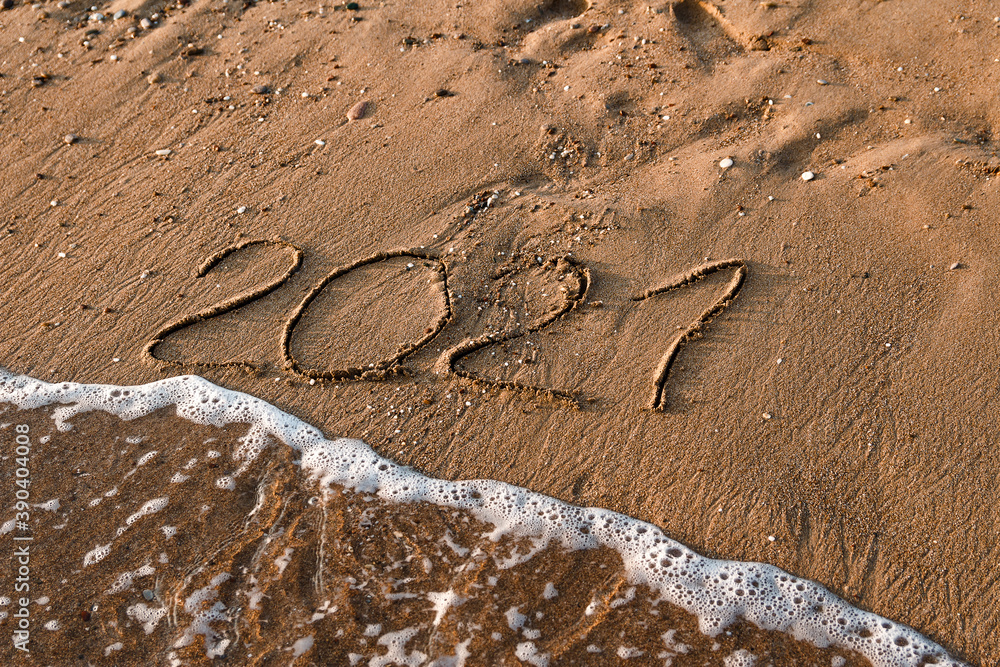 number 2021 is written on the sand at sea. waves and sand. 2021 number 2021 is written on the sand at sea. waves and sand. 2021