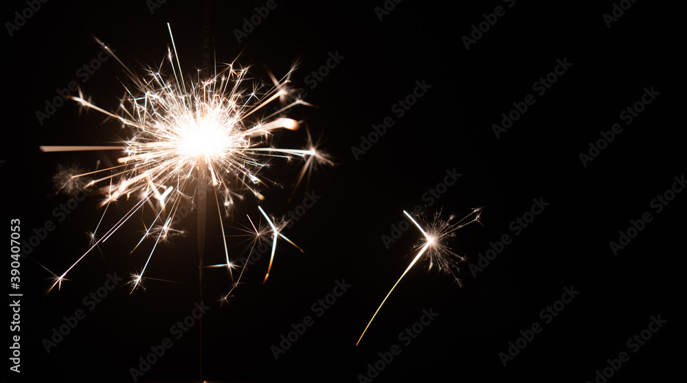 Obraz premium Burning sparkler on a black background with place for text. New year, birthday
