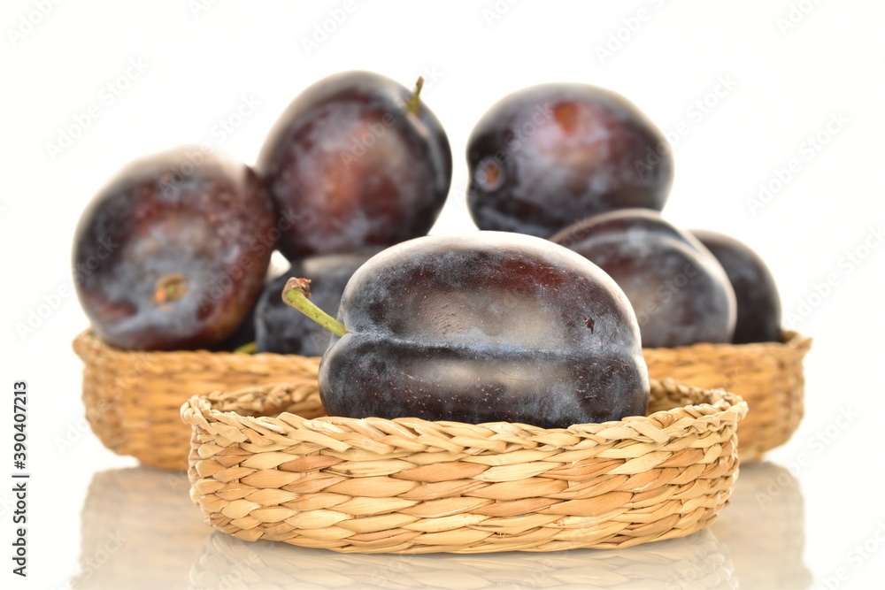 Fototapeta premium Ripe dark blue organic plums, close-up, on a white background.