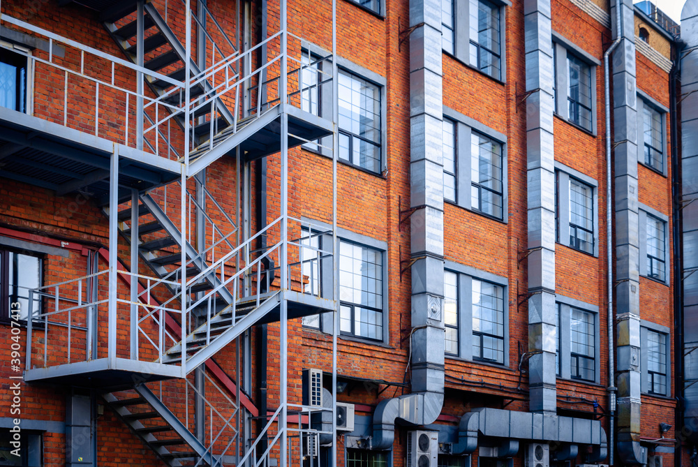 The facade of a brick building with a fire escape. The facade of a brick building with a fire escape.