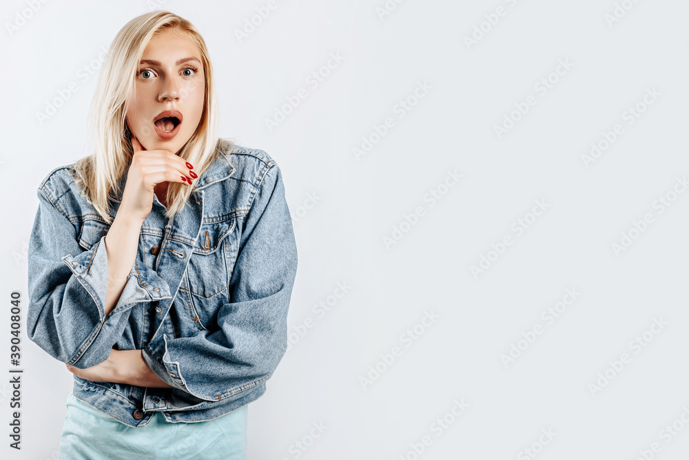 Beautiful young girl is surprised on gray isolated background Beautiful young girl is surprised on gray isolated background
