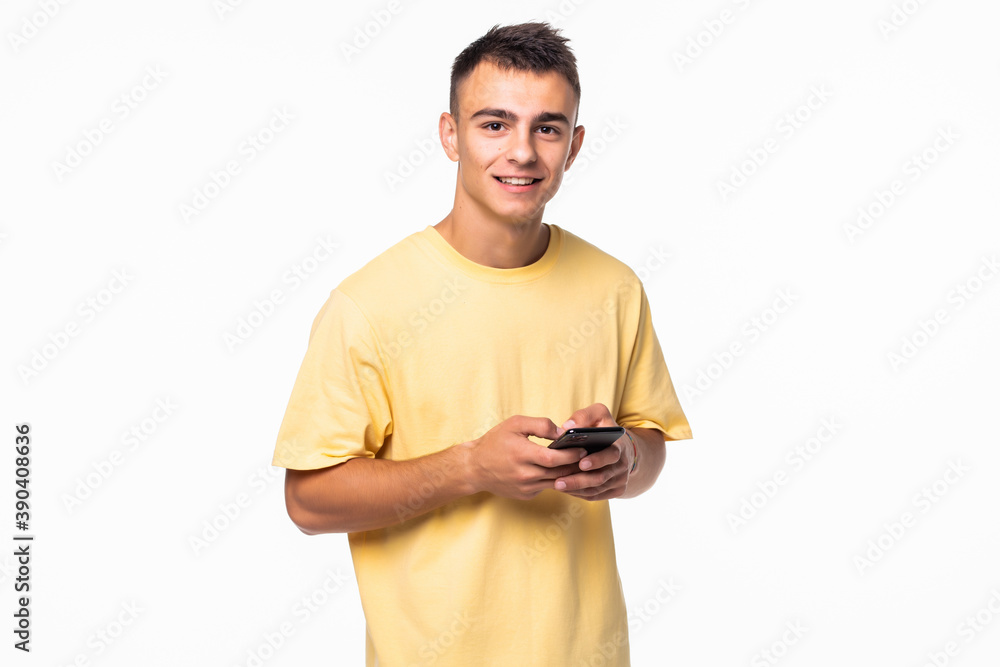 Portrait of young man typing on the phone isolated on gray background