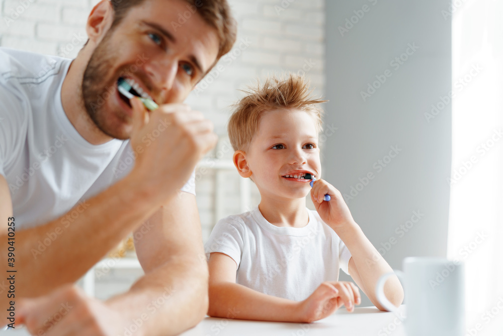 Dad and little son brushing teeth together Dad and little son brushing teeth together