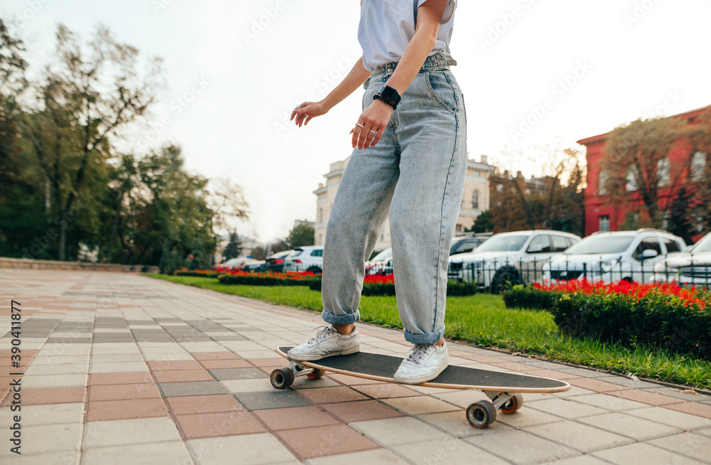 Woman skater in light casual clothes at speed rides on a longboard on the  sidewalk, cropped close-up photo. Woman skater walking down the street on a  skateboard Stock-Foto | Adobe Stock