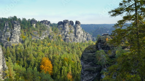 Bastei mit Felsenburg und Menschen in der  S  chsischen Schweiz mit Felsen und B  umen im Herbst
