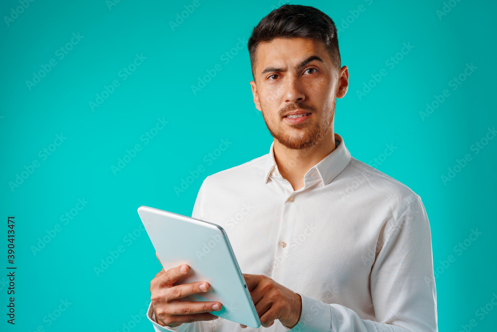Young businessman wearing white shirt holds digital tablet Young businessman wearing white shirt holds digital tablet