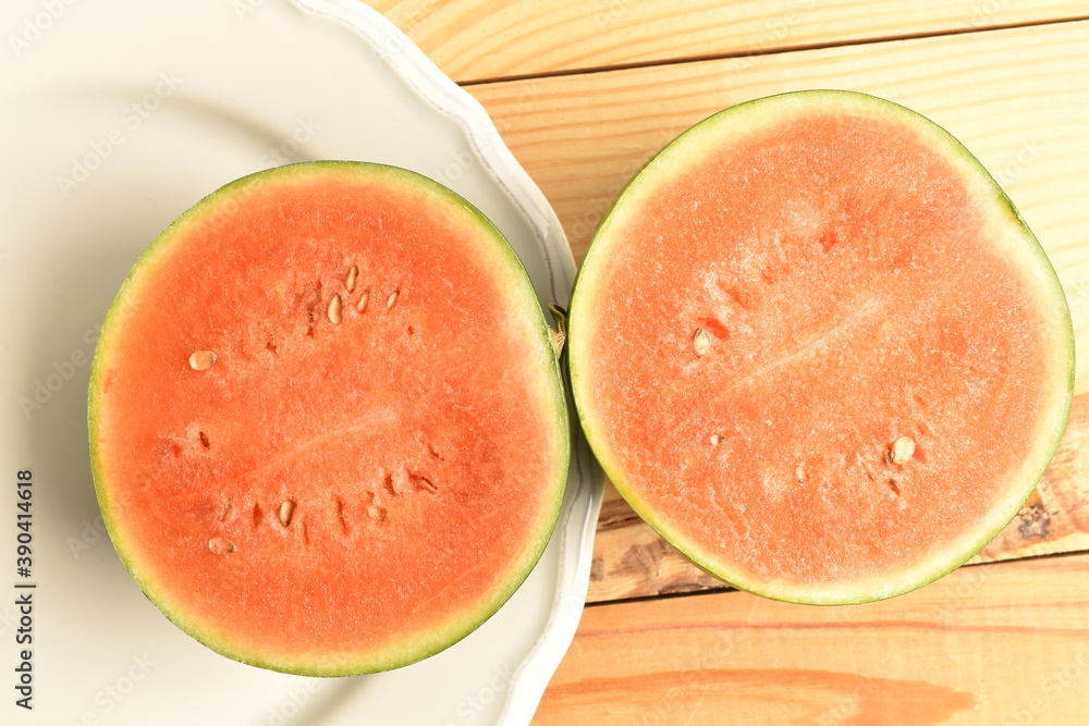 Sliced red organic watermelon, close-up, on a wooden table. Sliced red organic watermelon, close-up, on a wooden table.