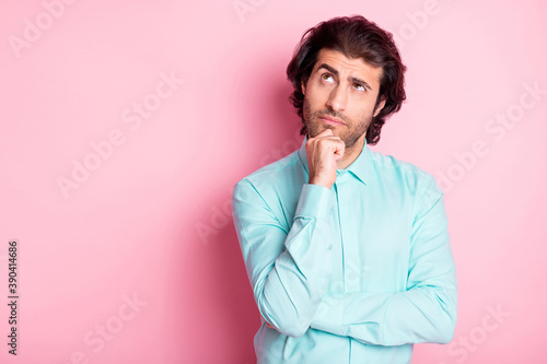 Photo portrait of dreamy man touching face chin with finger looking at blank space isolated on pastel pink colored background