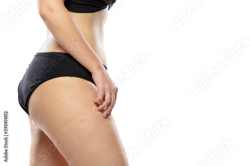 Side view. Overweight woman with fat cellulite legs and buttocks, obesity female body in black underwear isolated on white background. Orange peel skin, liposuction, healthcare and beauty treatment.