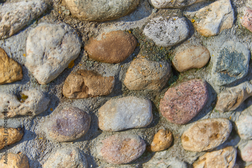 Full frame stonework made of cobblestones of different colors and sizes as a backdrop. Full frame stonework made of cobblestones of different colors and sizes as a backdrop.