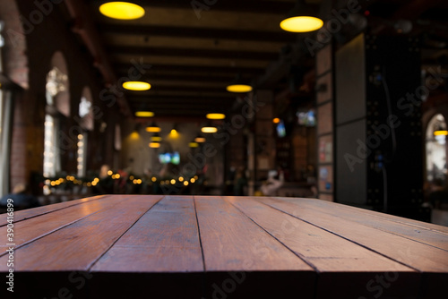 image of wooden table in front of abstract blurred background of resturant lights