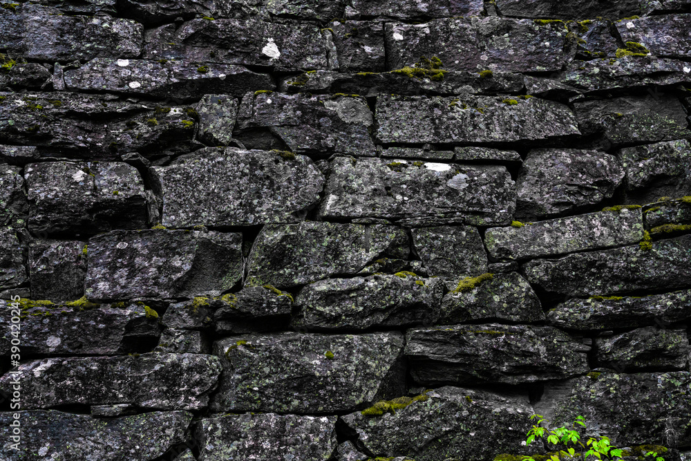 Medieval stone wall and arch architecture made from rough granite rocks. Close up.