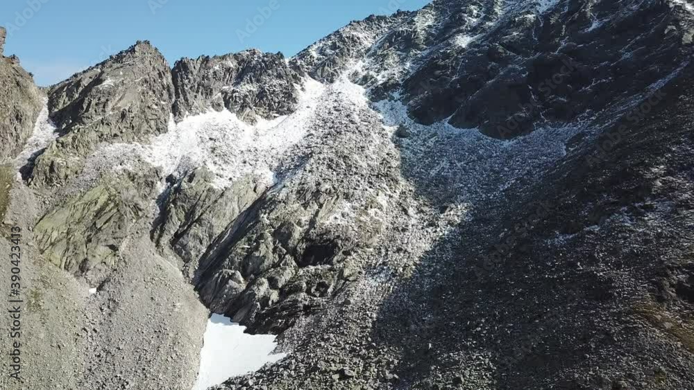 A panoramic drone shot of slopes in the Hohe Tauern region in Austria. The slopes are partially covered with snow. Upper parts steep and sharp. Early spring in the Alps. Serenity and calmness
A panoramic drone shot of slopes in the Hohe Tauern region in Austria. The slopes are partially covered with snow. Upper parts steep and sharp. Early spring in the Alps. Serenity and calmness