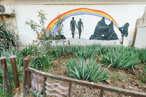 Giorgia, Tbilisi, 03.26.2018: drawing of a man and a woman under a rainbow on the hay in the garden photo