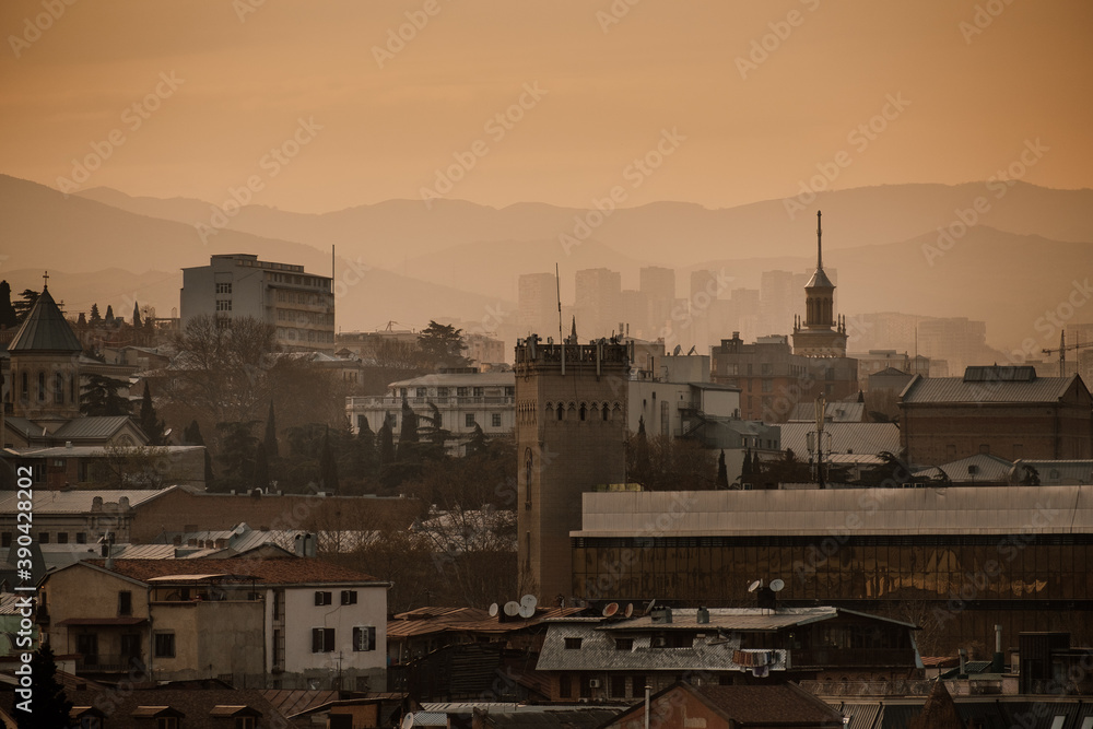 view of the city and mountains in the warm sunset light