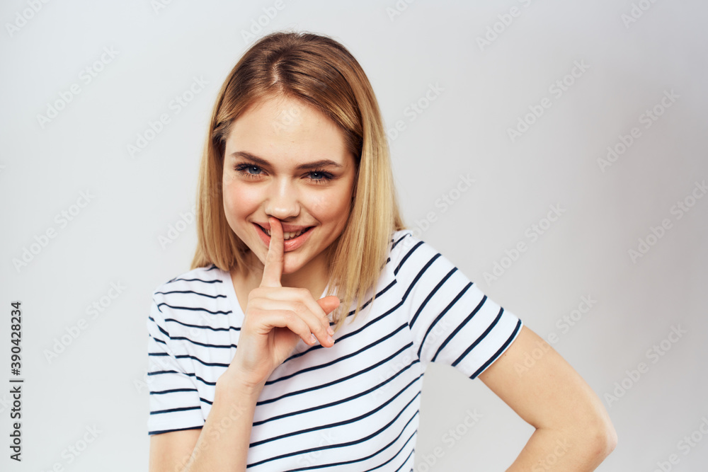 emotional woman in striped t-shirt gesture with hands lifestyle light background emotional woman in striped t-shirt gesture with hands lifestyle light background