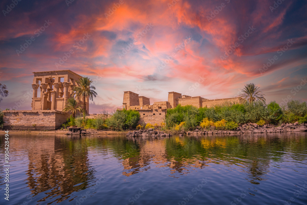 Incredible orange sunrise at the temple of Philae, a Greco-Roman construction seen from the Nile river, a temple dedicated to Isis, goddess of love. Aswan. Egyptian